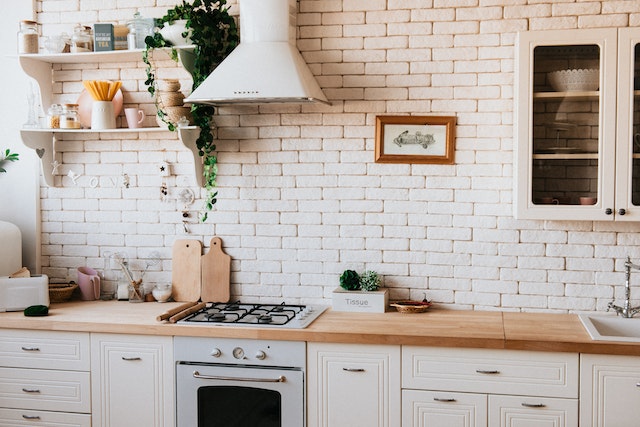 a kitchen with a white brick accent wall