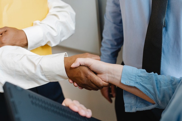 close up on professionally dressed individuals shaking hands