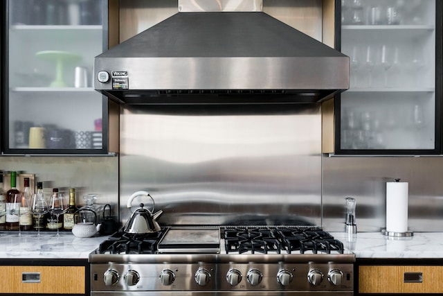 The stovetop and fan of a modern kitchen.